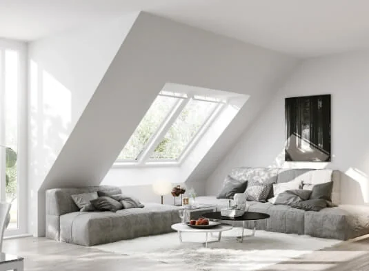 Heller Wohnraum mit Dachschräge, Sofa und Couchtisch — Beratungssituation bei Wolf & Sohn Immobilien